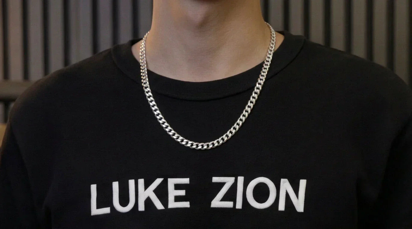photo - a main in a black sweater wearing acurb chain